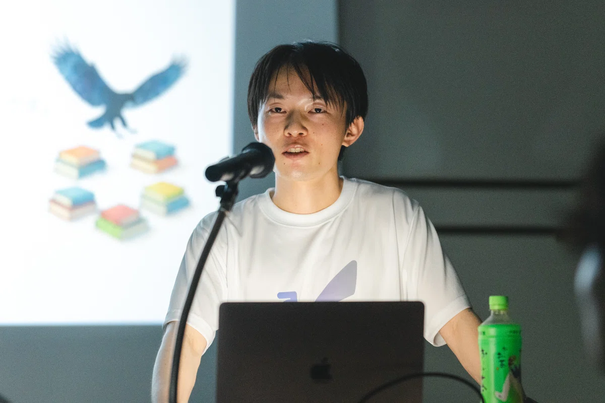 AIDBのロゴ入りTシャツを着て登壇する水谷健さん