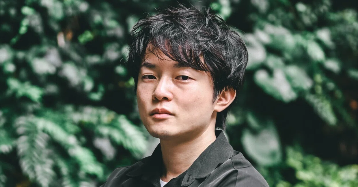 緑を背景にした株式会社Parks代表取締役兼CEOの水谷健さん